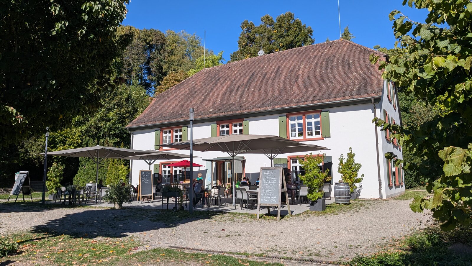Das helle Gasthaus am Lilienhof unter blauem Himmel.